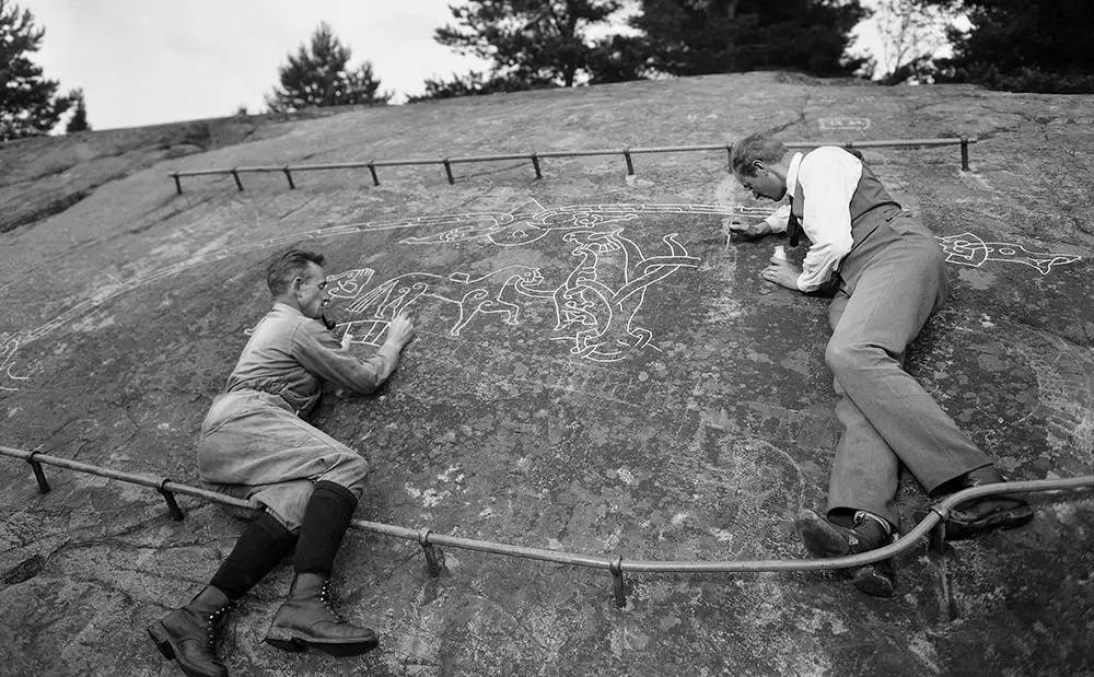 Dois homens, Harald Faith-Ell e Elias Wessén, pintando a “Sigurdsristningen” (gravura de Sigurd).
